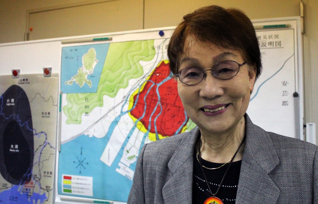 Following one of her talks at the Hiroshima Peace Memorial Park, Emiko Okada stands in front of a map showing the city’s destruction zone caused by the atomic bomb.