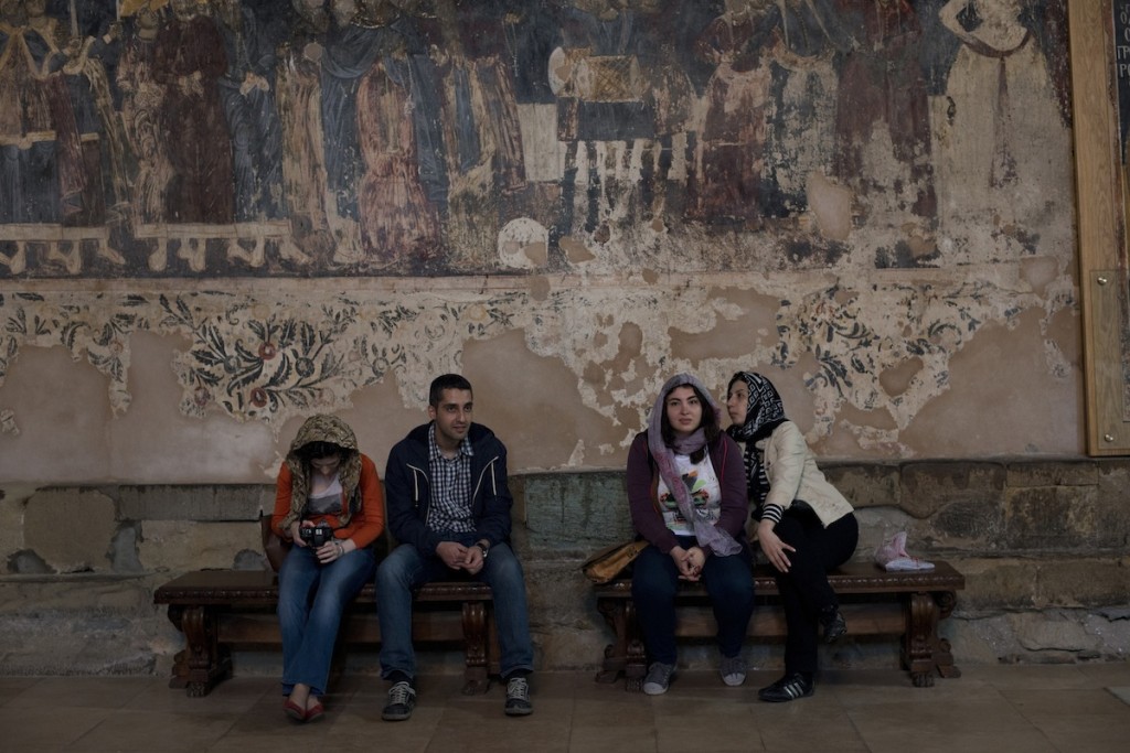 Georgian youth hang out and check their cell phones at a small church in Mtskheta, Georgia on May 1, 2014. Mtskheta is one of the holiest places in Georgia, but it's churches are filled with tourists and visitors.