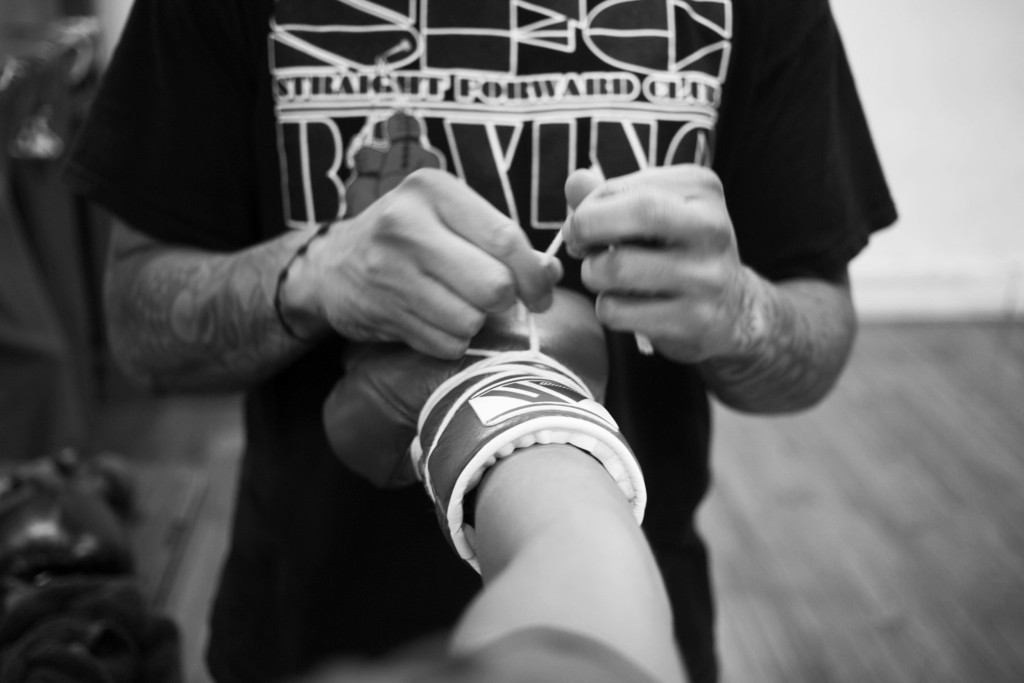 Casey's boxing glove is tightened in between a sparring session with another boxer as a part of Casey's training towards her boxing pro-debut at World Class Boxing Gym in San Francisco, CA.