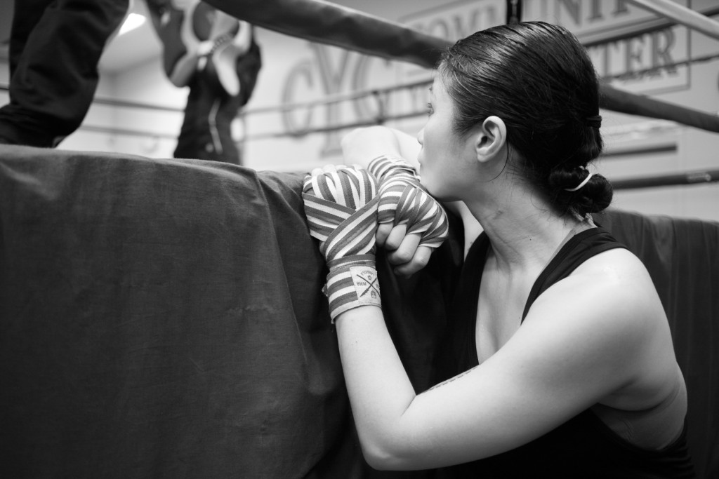 Casey takes some quiet time to rest and watch two young pupils practice sparring against one another in the ring at the Community Youth Center in Concord, CA.