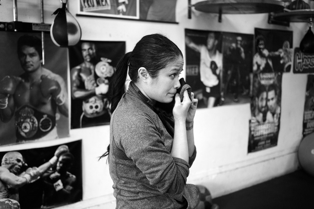 After doing a combination of different warm up exercises, Casey takes a moment to wipe off some sweat and listen to Coach Jairo's critiques at World Class Boxing Gym in San Francisco, CA.